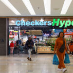 Shoppers leave after shopping at an outlet of retailer Checkers in Sandton